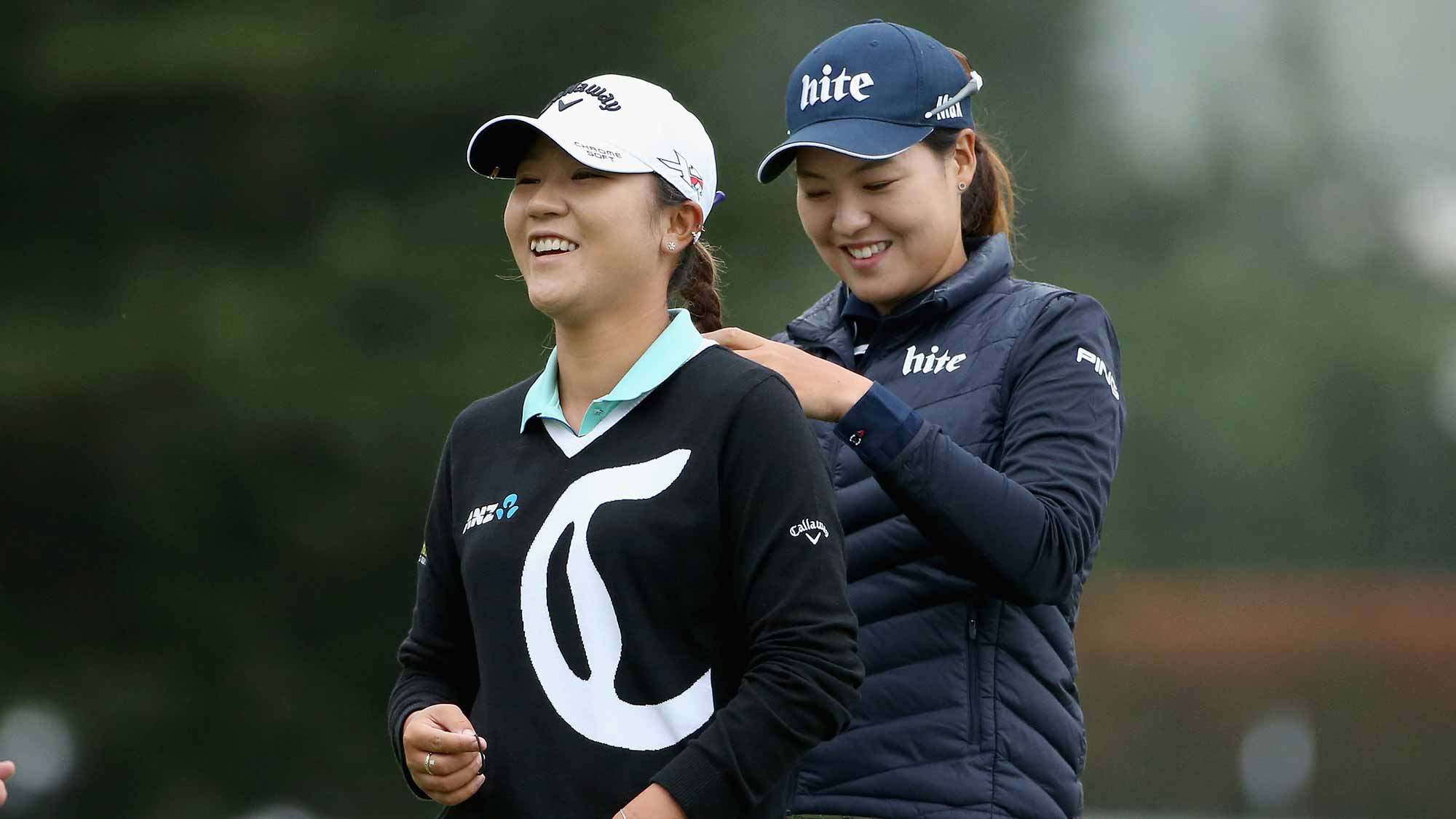 In Gee Chun of South Korea braids the hair of Lydia Ko of New Zealand on the 10th hole green during round one of the Swinging Skirts LPGA Classic at Lake Merced Golf Club