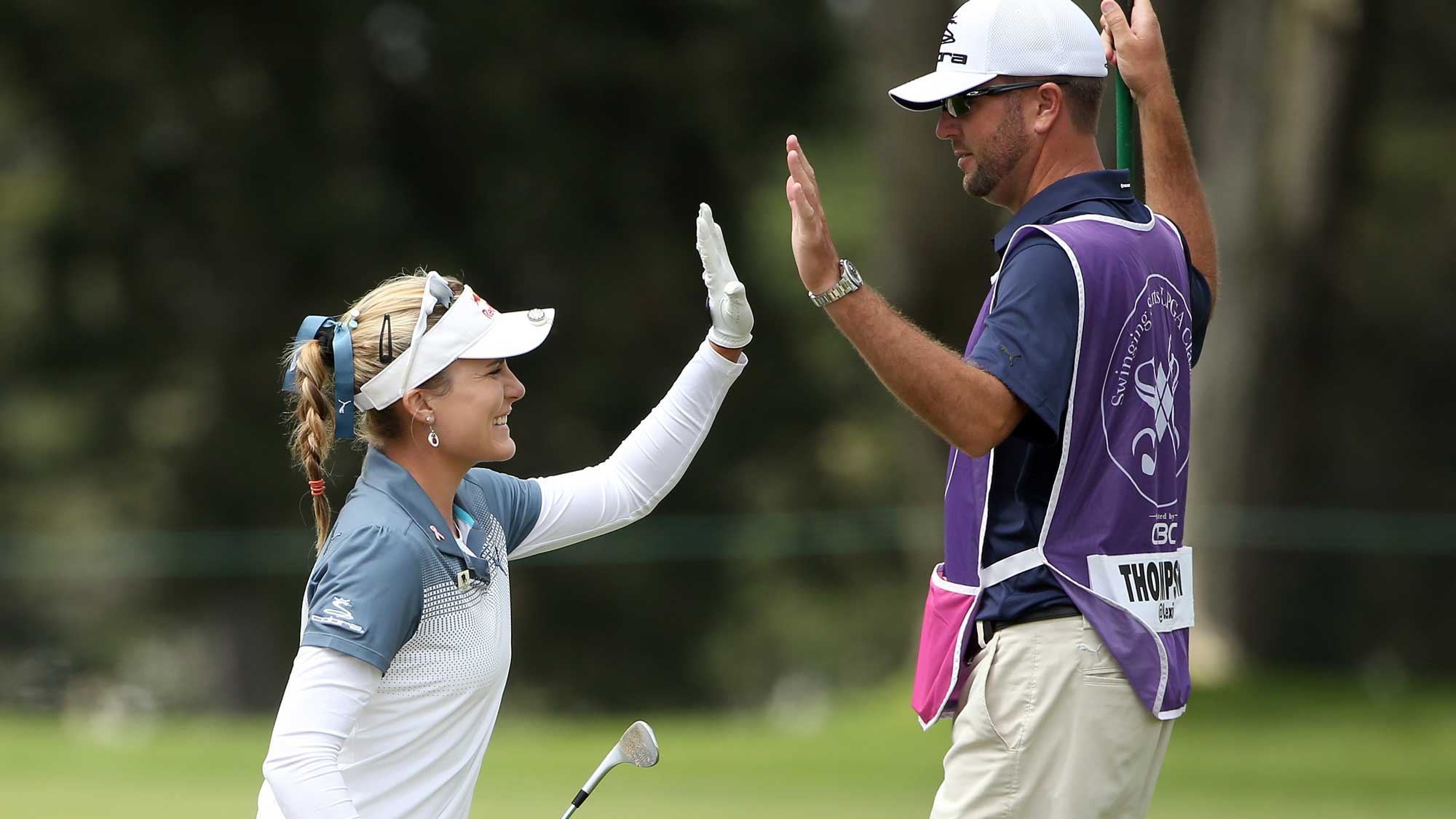 Lexi Thompson high-fives her caddie, Benji Thompson, after she chipped in for eagle on the sixth hole during round one of the Swinging Skirts LPGA Classic