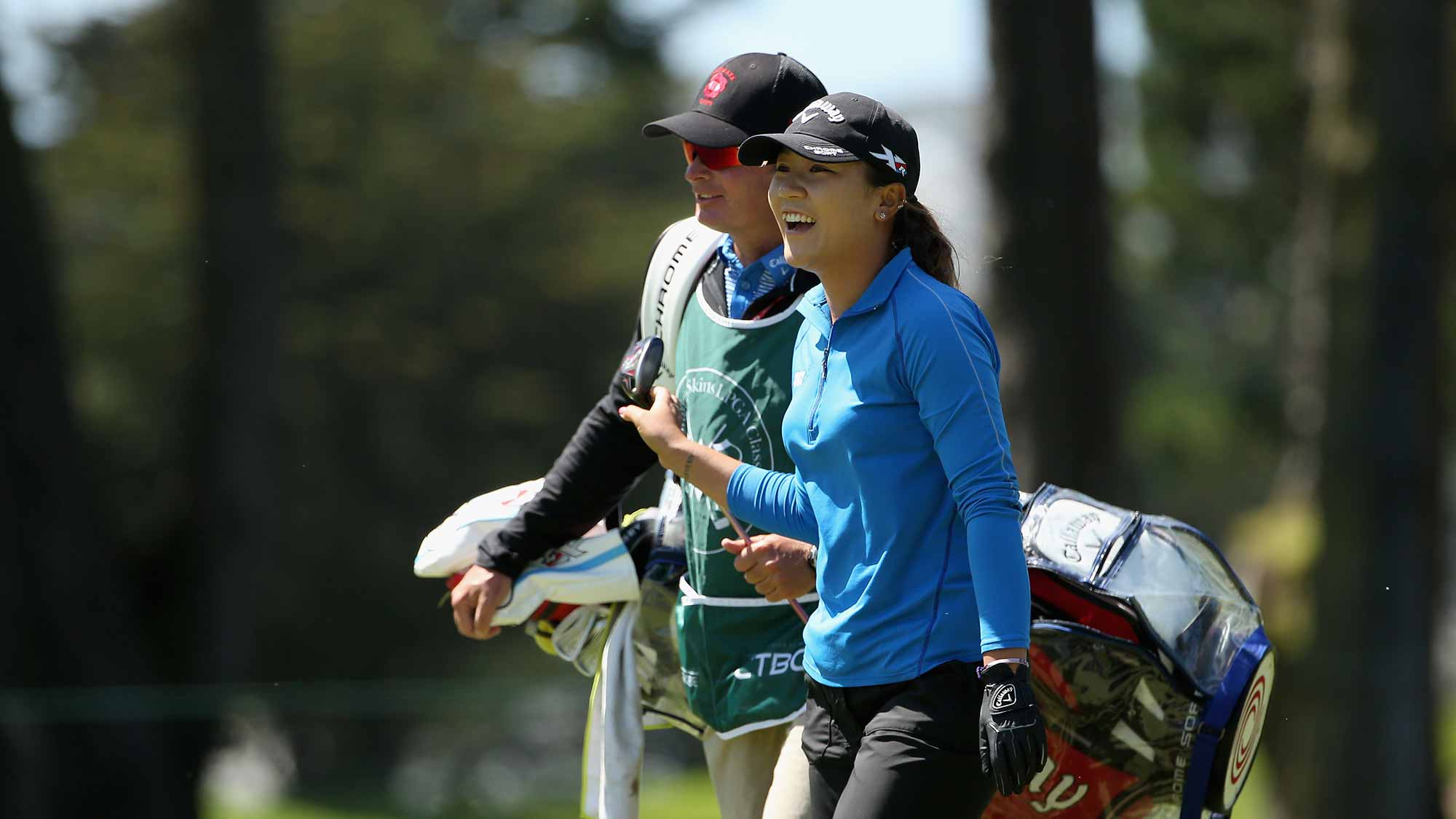 Lydia Ko of New Zealand laughs with her caddie, Jason Hamilton, after hitting her second shot on the sixth hole during round two of the Swinging Skirts LPGA Classic at Lake Merced Golf Club